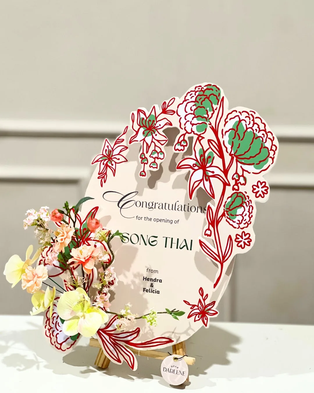 Papan bunga Classic Dear Darlene di atas meja dengan tulisan ucapan pembukaan